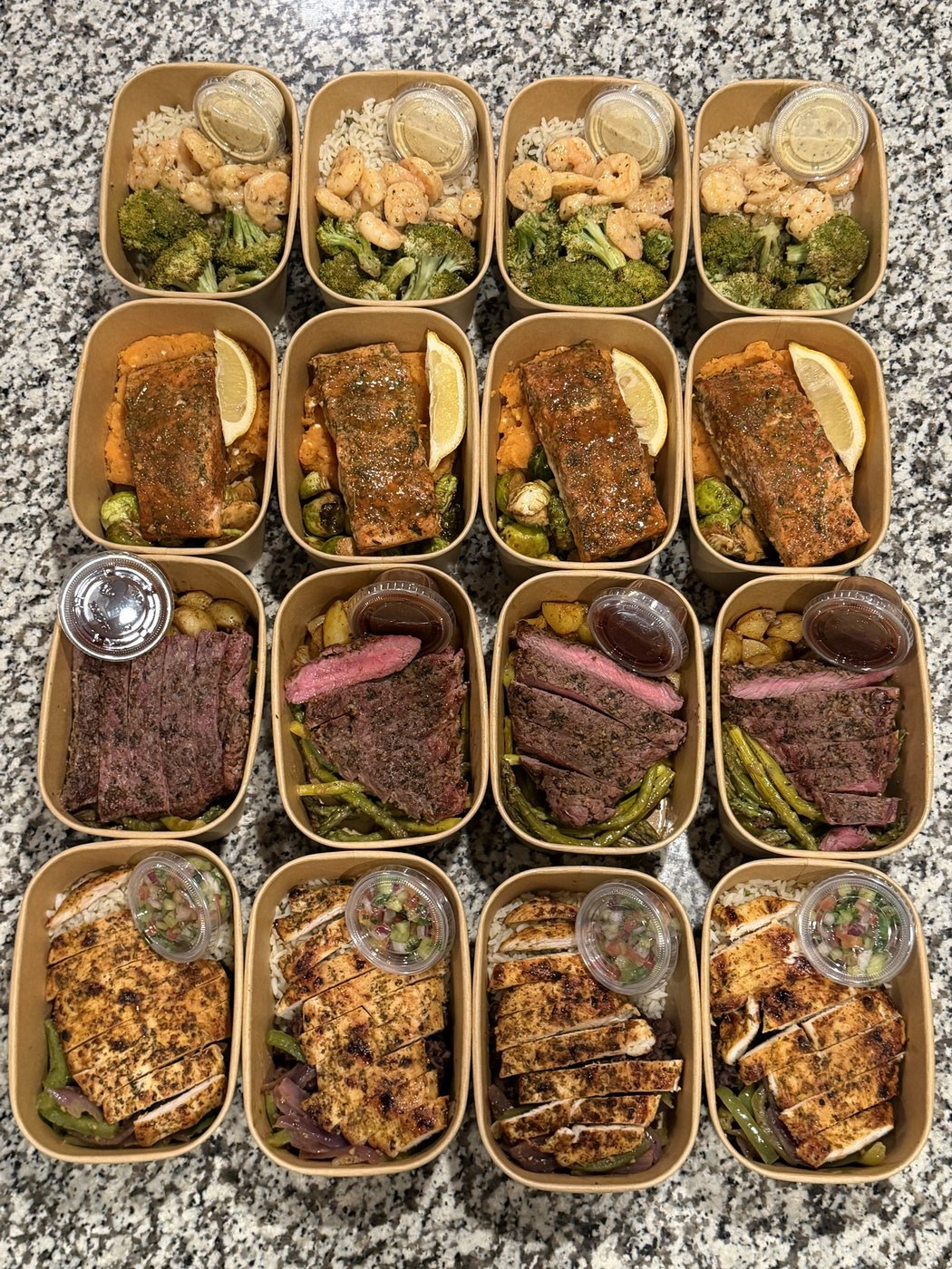 Sixteen packed meals with shrimp, salmon, steak and chicken